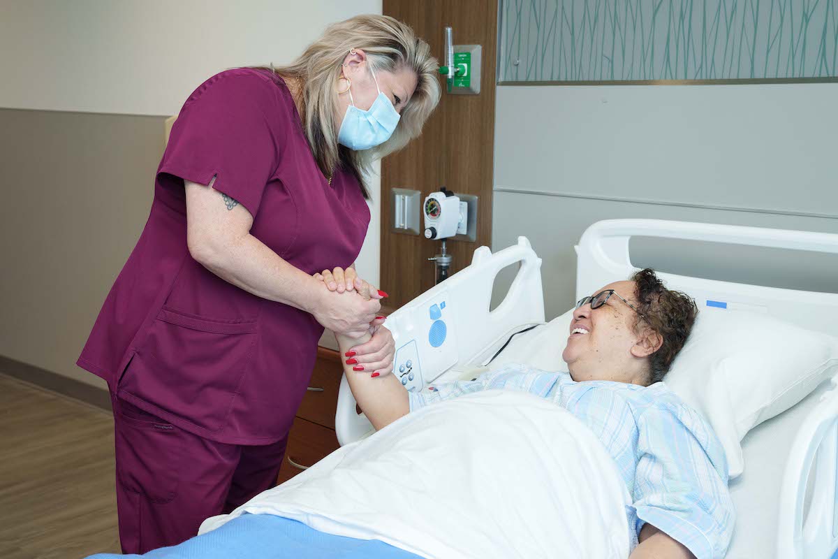 Rehab nurse technician holds patients hand